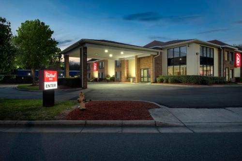 a fire hydrant in front of a building with a for sale sign at Red Roof Inn Charlotte - University in Charlotte