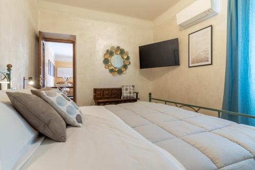 a bedroom with a large white bed with a flat screen tv at Giadera penthouse 5terreparco in Riomaggiore