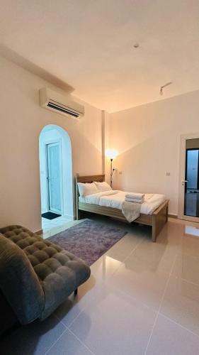 a bedroom with a bed and a couch in a room at River & Sky Homes 6004 in Abu Dhabi