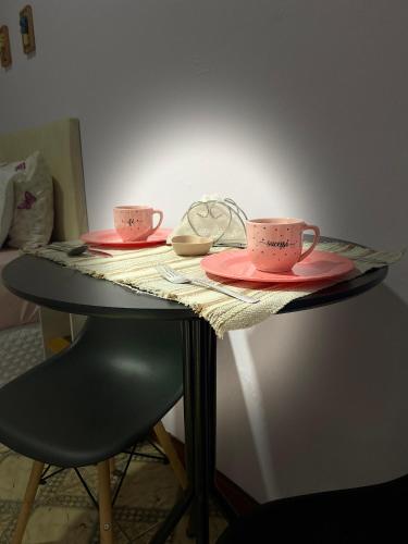 two pink cups and saucers on a table at Suítes Aconchego dos Pinhais in Santo Antônio do Pinhal