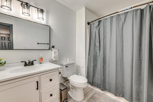 a bathroom with a toilet and a shower curtain at Townhome 1 Mi to Colt Park and Industrial District! in Hartford