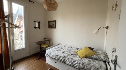 Appartement ancien cosy في دْييب: غرفة نوم عليها سرير ومخدة صفراء