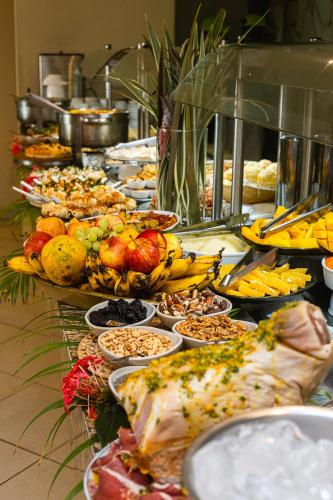 um bufê com muitos tipos diferentes de comida em uma mesa em Baía Branca Beach Resort em Tamandaré