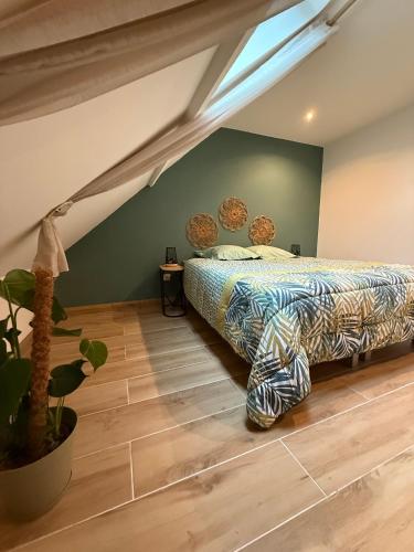 une chambre avec un lit et une plante en pot dans l'établissement douceur d opale, à Boulogne-sur-Mer