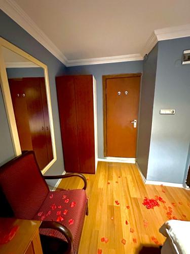 an empty living room with a red chair and wooden floors at Cendere Old City Hotel in Istanbul