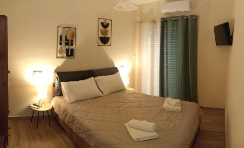 a bedroom with a bed with two towels on it at Philoxenia Apartments in Kryonéri