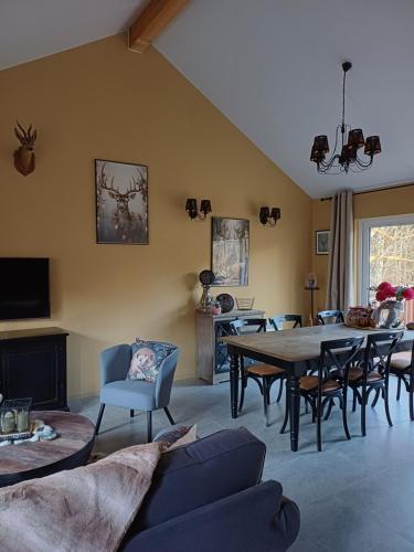 a living room with a table and chairs at Châlet des Cerfs Durbuy in Somme-Leuze