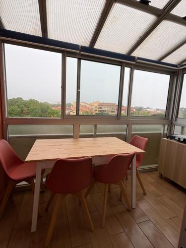 une table et des chaises dans une pièce avec des fenêtres dans l'établissement Appartement Cosy Parking, Plage & Commerces à Deux Pas, à Argelès-sur-Mer