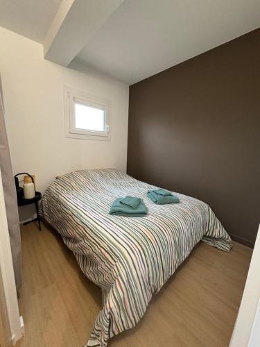 a bedroom with a bed with two towels on it at Appartement Cosy Parking, Plage & Commerces à Deux Pas in Argelès-sur-Mer