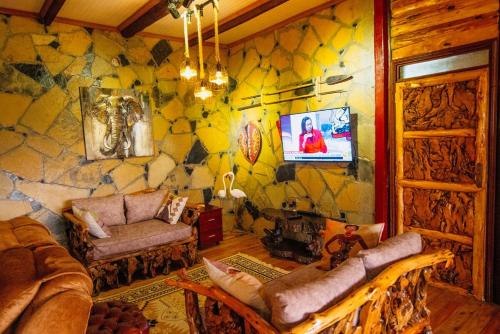 a living room with a stone wall at Thitu Log House in Nakuru