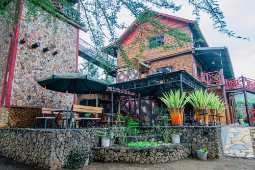 a building with a table and an umbrella at Thitu Log House in Nakuru