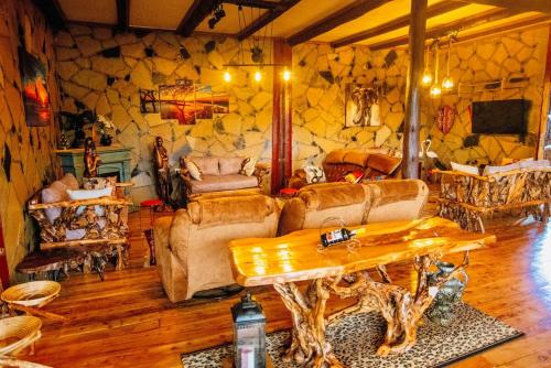 a living room with a table and a stone wall at Thitu Log House in Nakuru