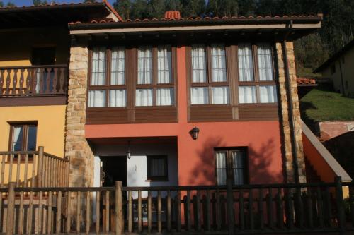 a house with a wooden fence in front of it at Apartamentos Rurales Obaya in Villaviciosa