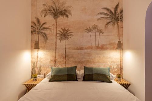 a bedroom with a bed with palm trees on the wall at K-PALM by Nuka Homes in Jávea