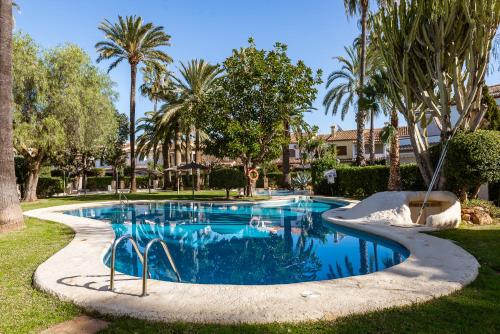 a swimming pool in a yard with palm trees at K-PALM by Nuka Homes in Jávea