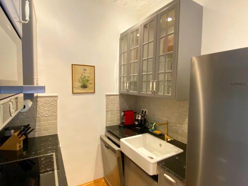 a small kitchen with a sink and a refrigerator at 7th HEAVEN Vienna Center Apartments in Vienna