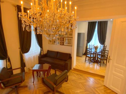 a living room with a couch and a chandelier at 7th HEAVEN Vienna Center Apartments in Vienna