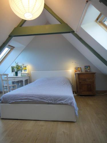 - une chambre mansardée avec un lit et une table dans l'établissement Gîte des Hortensias - Old farmhouse - Sea view, à Carantec
