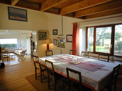 une salle à manger avec une table et des chaises dans une pièce dans l'établissement Gîte des Hortensias - Old farmhouse - Sea view, à Carantec