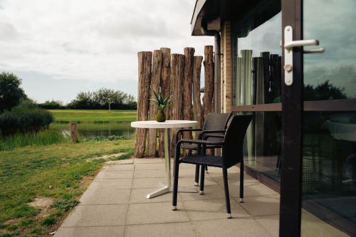 two chairs and a table on a porch at Resort Land & Zee in Scharendijke