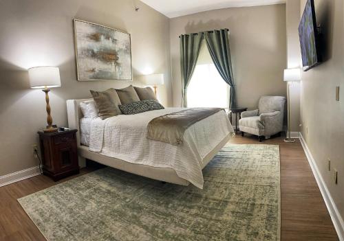 a bedroom with a bed and a chair and a window at Coldwater Inn - The Shoals Boutique Hotel in Tuscumbia