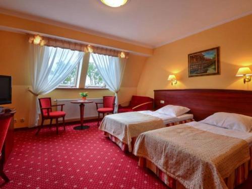 a hotel room with two beds and a table at Pensjonat Solis Sarbinowo in Sarbinowo