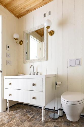 a bathroom with a white sink and a toilet at Villa Les Arches in La Malbaie