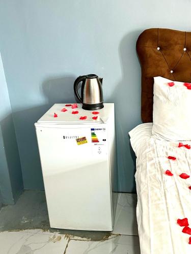 a white refrigerator next to a bed with a tea kettle on it at Cendere Old City Hotel in Istanbul
