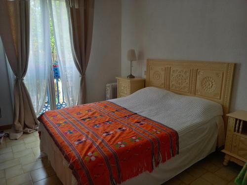 une chambre avec un lit et une fenêtre avec des rideaux dans l'établissement La Petite Maison de Charme, à Argelès-sur-Mer