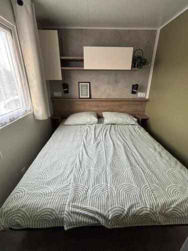 a bed in a small room with a large bed sidx sidx sidx at Chalet Drentse Lente in Gasselte