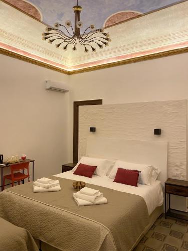 a bedroom with a large bed with a chandelier at Soste Normanne in Palermo