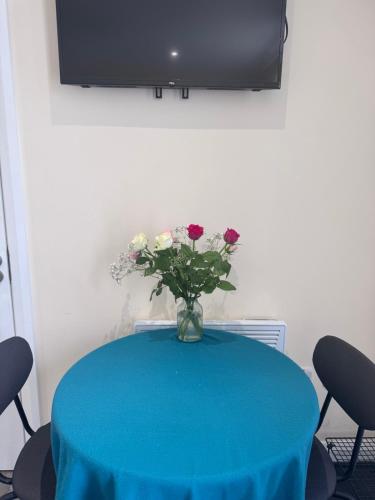 a blue table with a vase of flowers on it at Cosy Space near Dublin Airport and City in Dublin