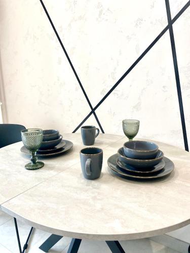 a white table with plates and cups on it at Апартаменти Люкс, Центр, ЖК Яровиця,Паркомісце in Luts'k