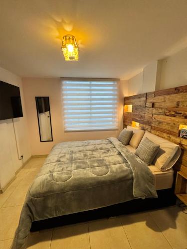 a bedroom with a large bed and a window at Apartamento en Manizales - Chipre in Manizales