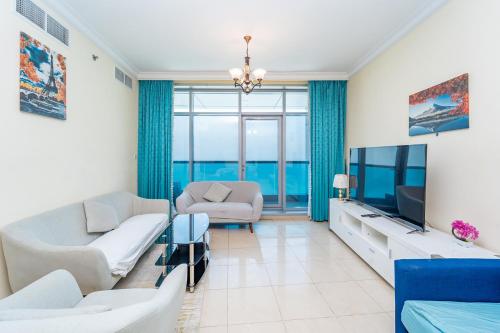 ein Wohnzimmer mit Sofa und Fernseher in der Unterkunft Beachfront holiday homes with beach,sauna,jacuzzi,cafe,restaurants and more in Ajman 