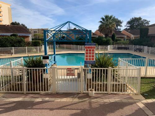- une piscine avec un portail et une montagne dans l'établissement Les Anglade, au Lavandou