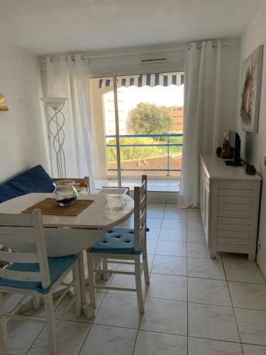 une salle à manger avec une table et des chaises et une fenêtre dans l'établissement Les Anglade, au Lavandou