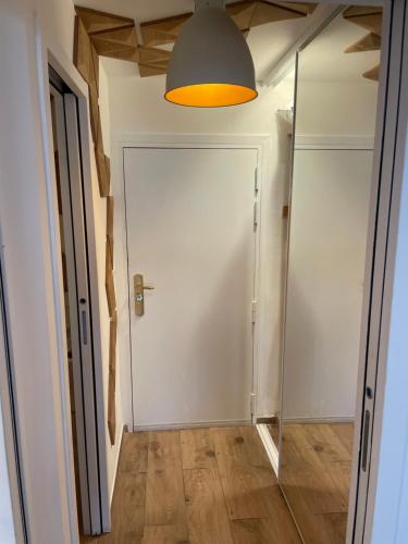 un couloir avec une porte blanche et un miroir dans l'établissement Appartement Saint-Tropez, à Saint-Tropez