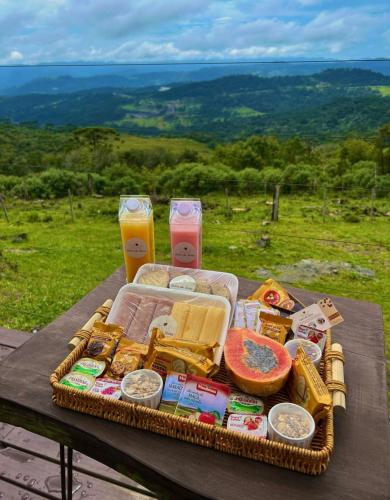 een picknickmand met eten en twee drankjes op een tafel bij Ninho da Águia - Cabana A in Urubici