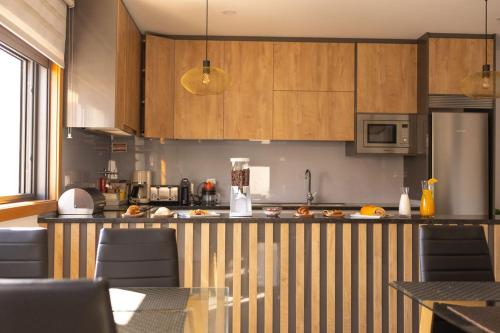 een keuken met houten kasten en een aanrechtblad bij Douro Elegance Suites in Torre de Moncorvo
