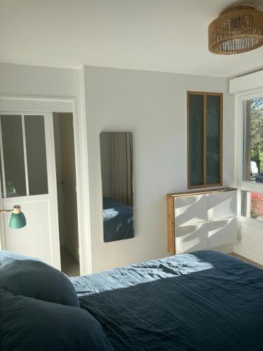 une chambre avec un lit et un miroir dans l'établissement Appartement familial T4 Bayonne, à Bayonne