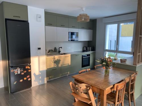 une cuisine avec une table en bois et un réfrigérateur dans l'établissement Appartement familial T4 Bayonne, à Bayonne