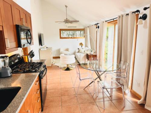 una cucina con tavolo in vetro e un soggiorno di Cozy cottage by the beach a Hampton Bays
