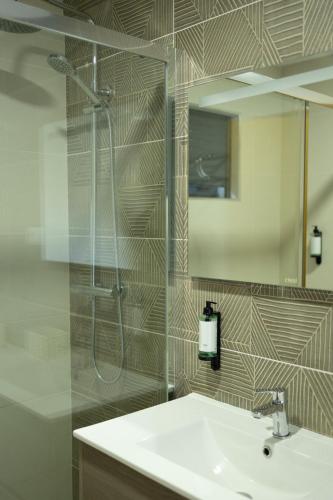 a bathroom with a sink and a shower and a mirror at Douro Elegance Suites in Torre de Moncorvo