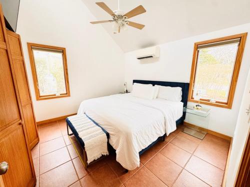 una camera con un letto bianco e due finestre di Cozy cottage by the beach a Hampton Bays