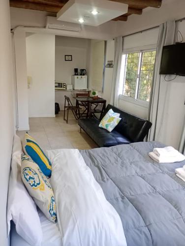 ゴドイ・クルスにあるGasparetto Lofts Mendozaの大きなベッドとリビングルームのある寝室