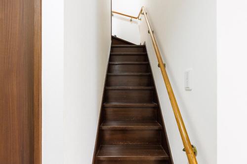 a staircase in a building with wooden floors and a railing at ビーチまで車で2分 BBQセットあり 車2台駐車可能 バリアフリーok Terrace Garden Okinawa in Yamada