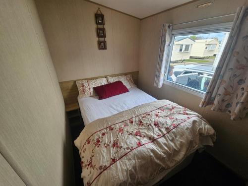 a small bedroom with a bed and a window at Ose's Cottage in Banks