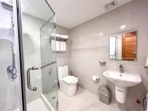 a bathroom with a toilet and a sink and a shower at Playa Azul Baler in Baler