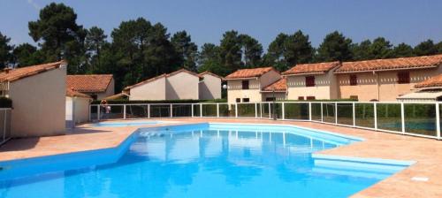 une grande piscine devant certains bâtiments dans l'établissement Le Duplex des Mathes, aux Mathes